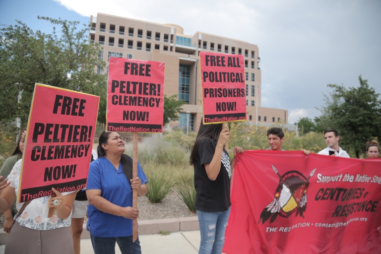 Peltier supporters held signs that read "Free Peltier, Clemency Now" and "Free All Political Prisoners."
